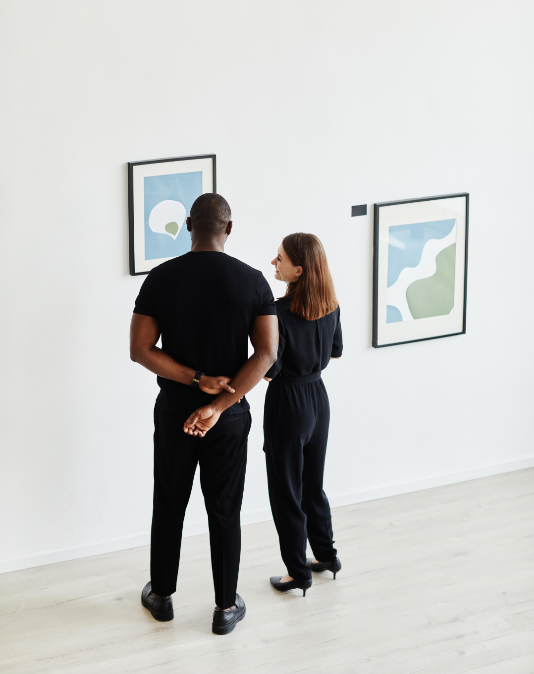Two people looking at artworks